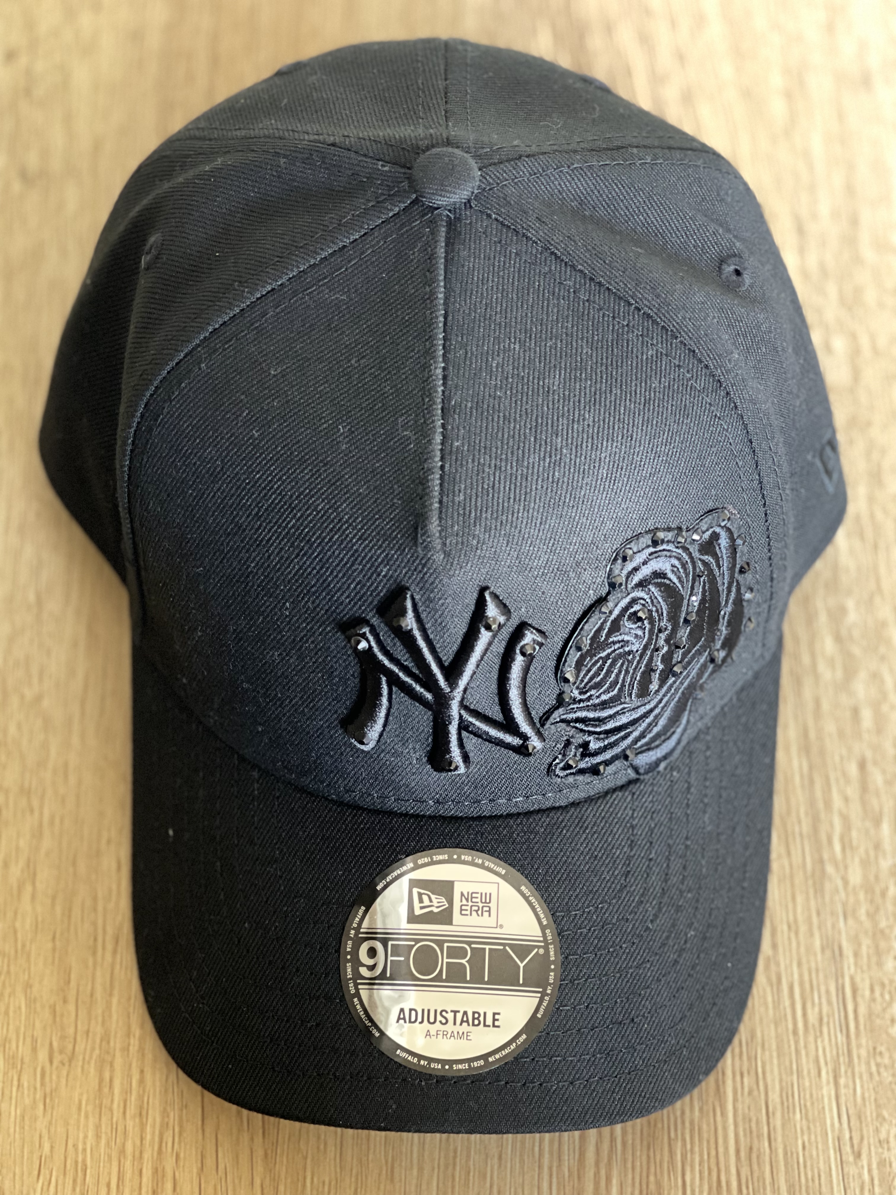 Black Yankees snapback with tonal black rose applique, angled top view.